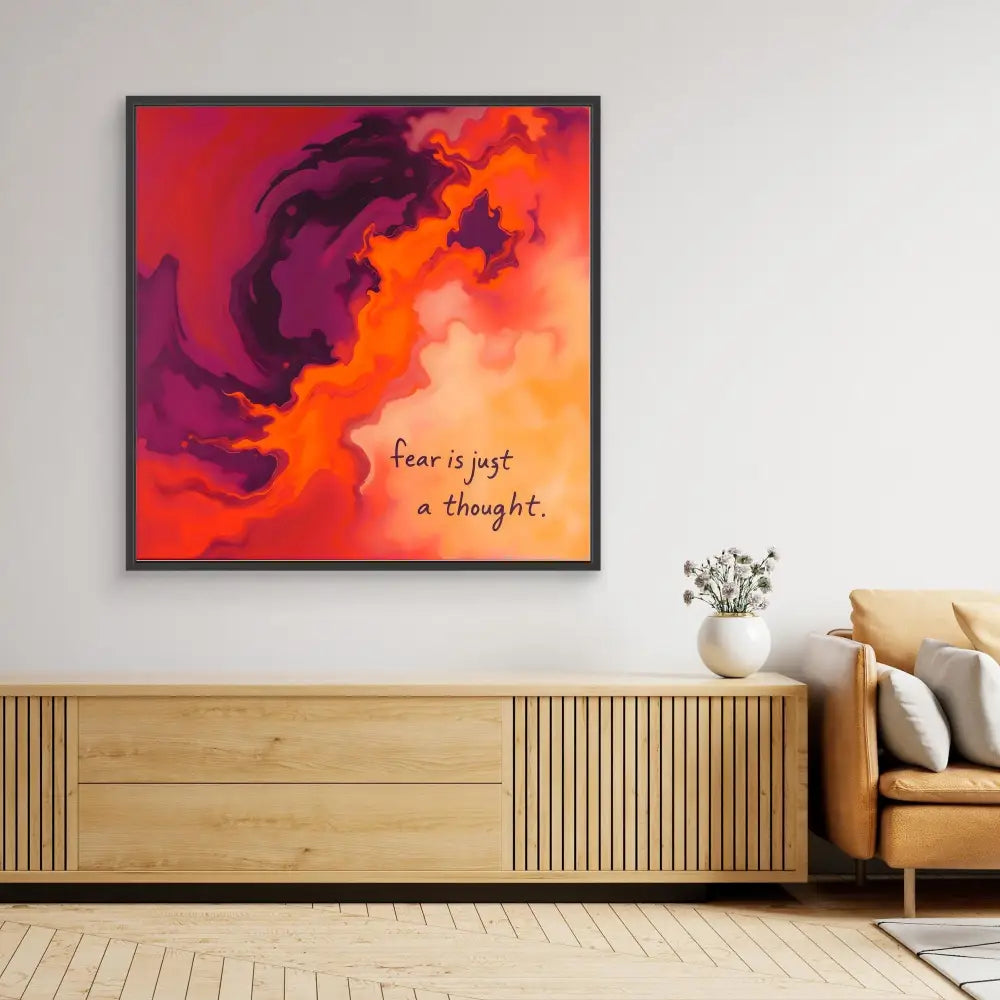 Framed abstract artwork with swirling orange and purple clouds featuring text that reads ’Fear is just a thought’