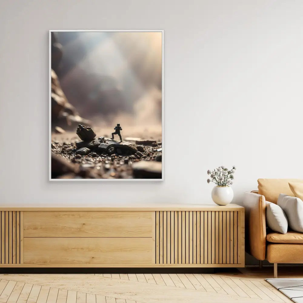 A framed artistic photograph of a silhouetted figure pushing a boulder mounted above a wooden credenza.