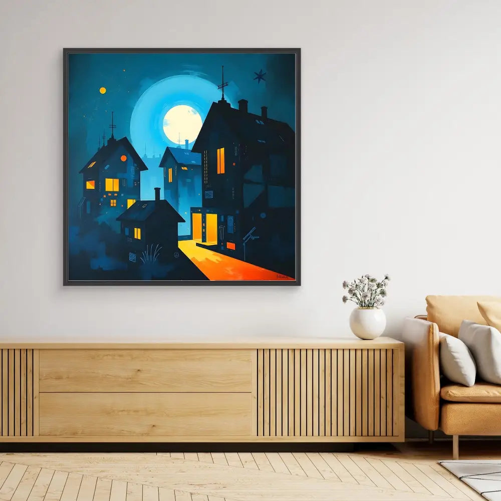 A framed artwork depicting illuminated houses against a night sky with a full moon.