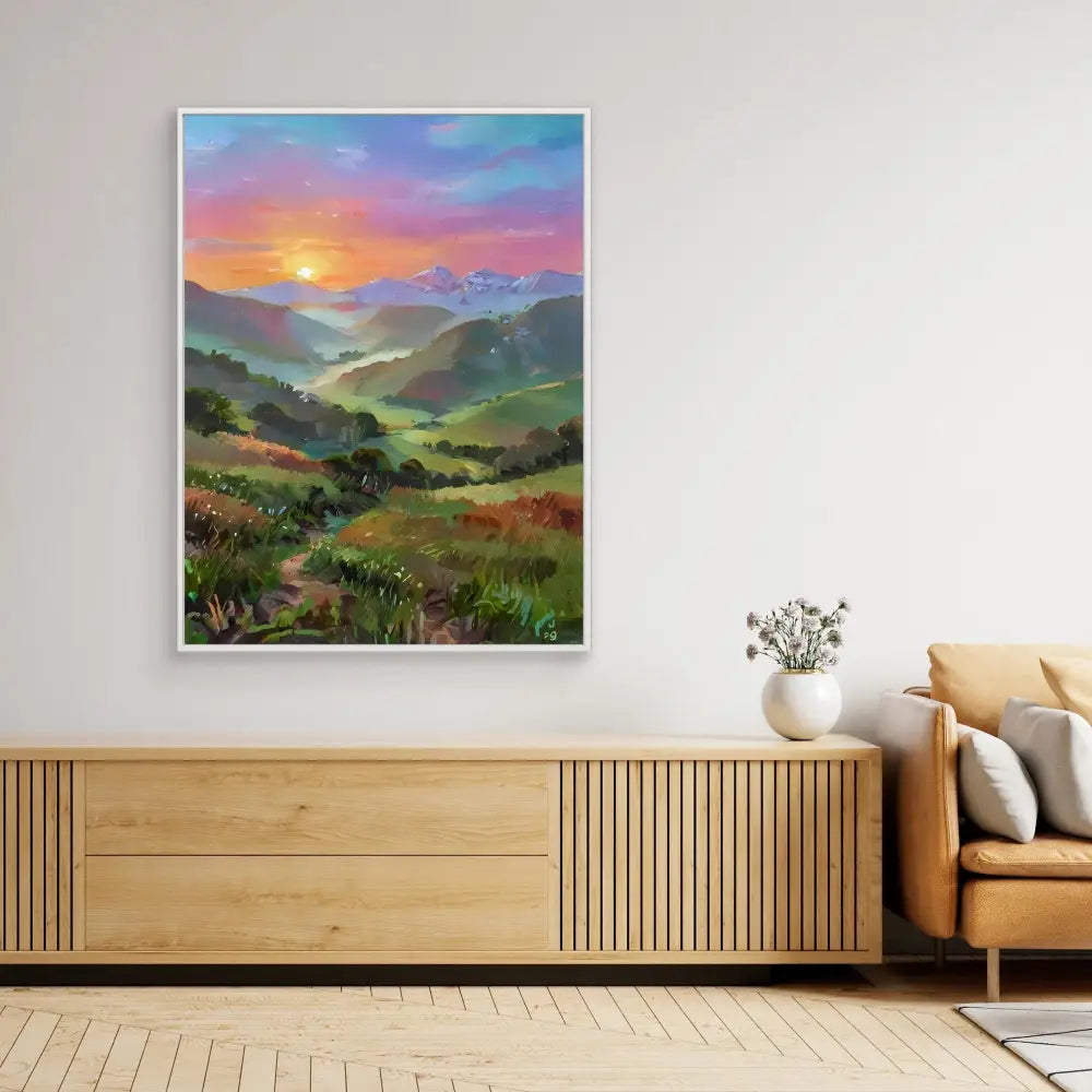 A framed landscape painting depicting rolling hills and a colorful sunset.