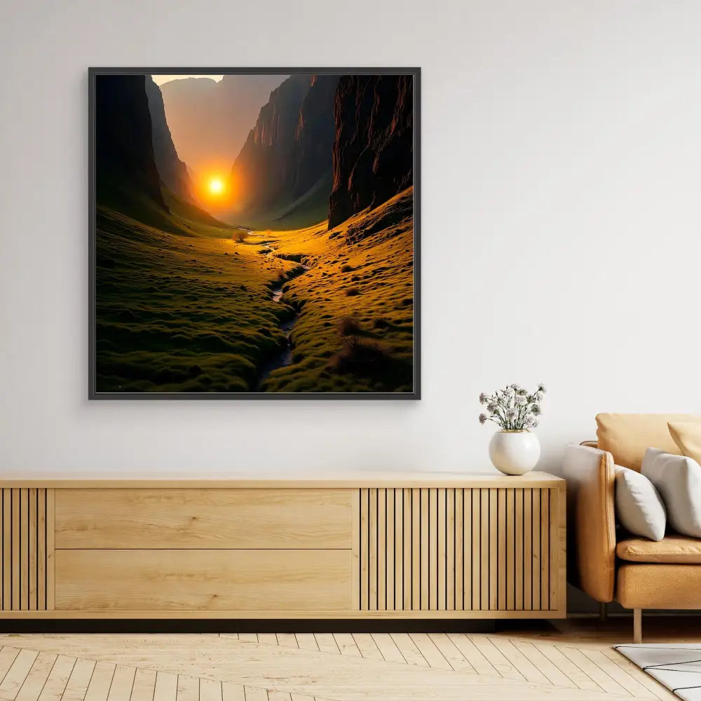 A framed landscape photograph showing a dramatic canyon with a setting sun and winding stream.