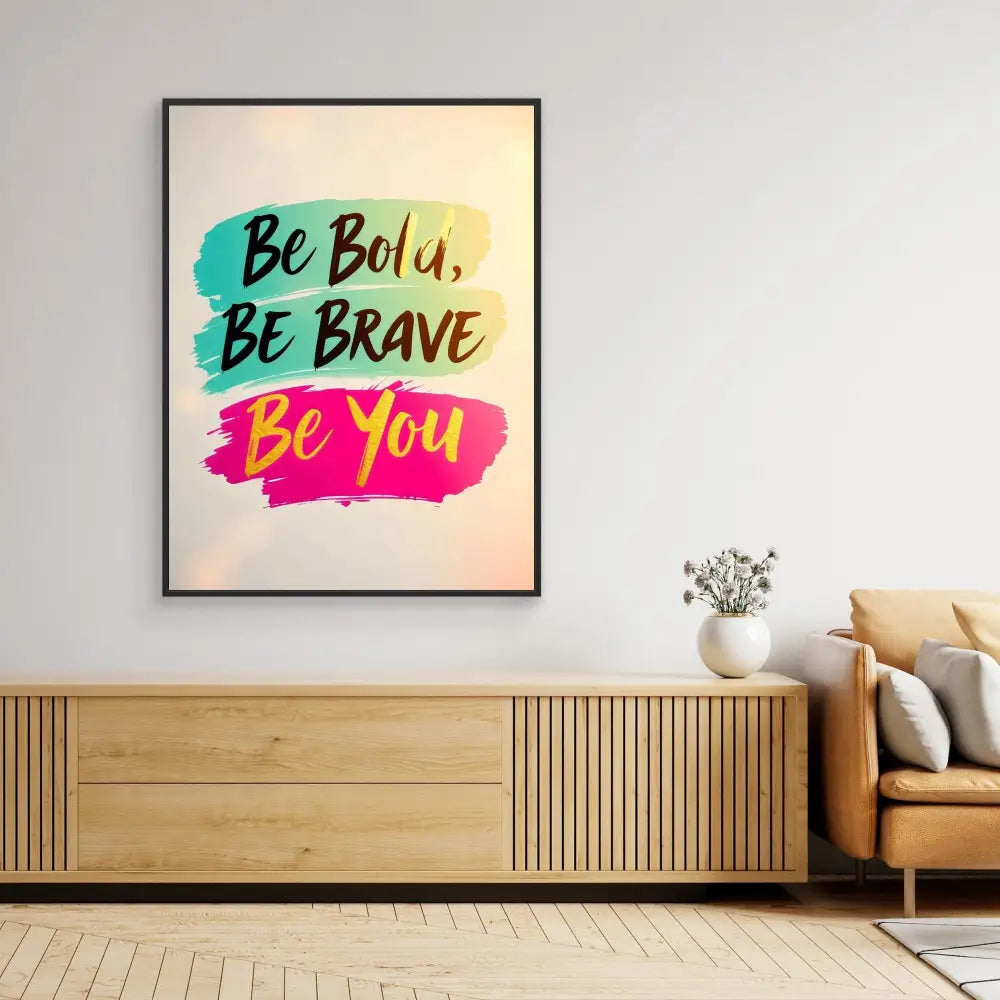 A framed motivational poster featuring the text ’Be Bold, Be Brave, Be You’ in turquoise and pink brushstroke designs.