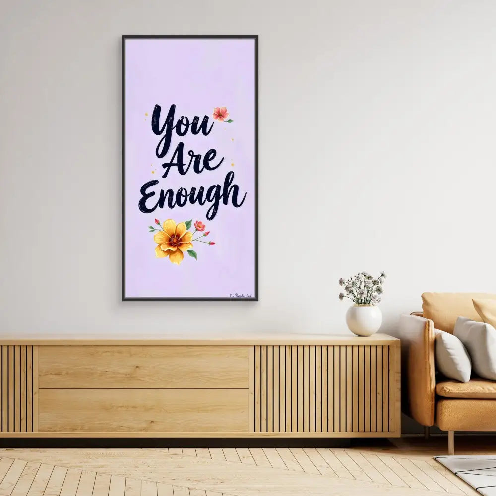 A framed motivational wall art featuring ’You Are Enough’ text with floral accents on a lavender background.