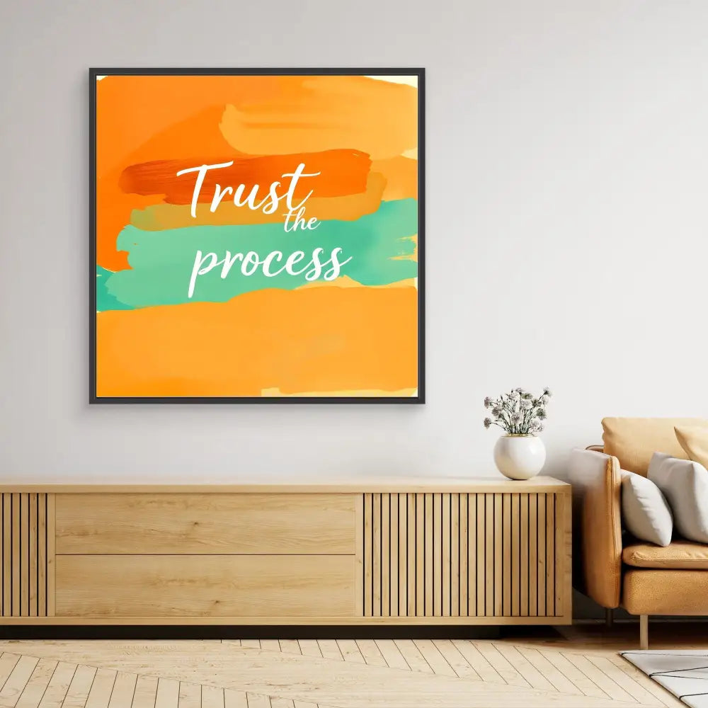 Framed motivational wall art featuring ’Trust the process’ text on orange and teal brushstrokes.