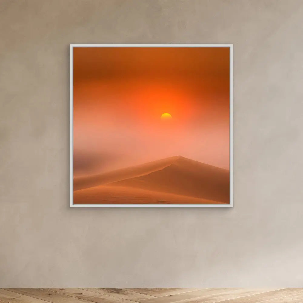 Framed photograph of a desert sunset over sand dunes.