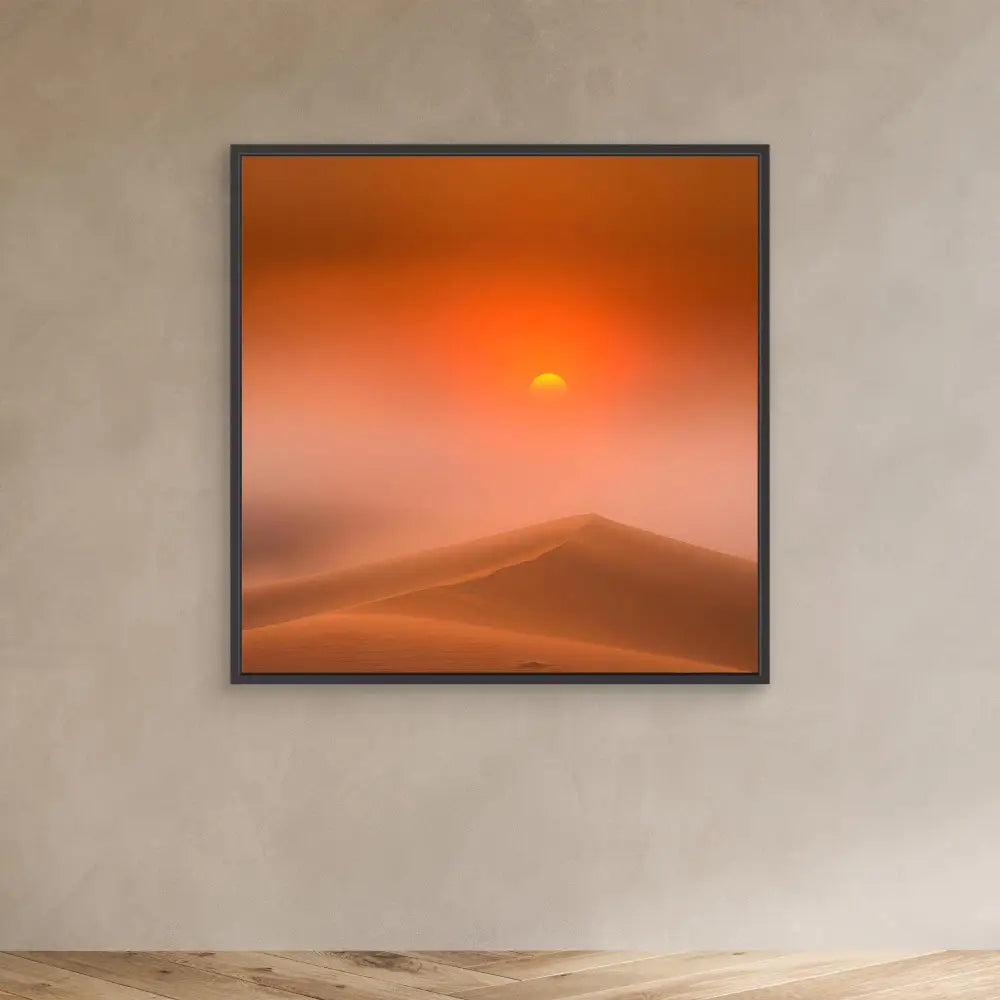 Framed photograph of a desert sunset over sand dunes with an orange-tinted sky.