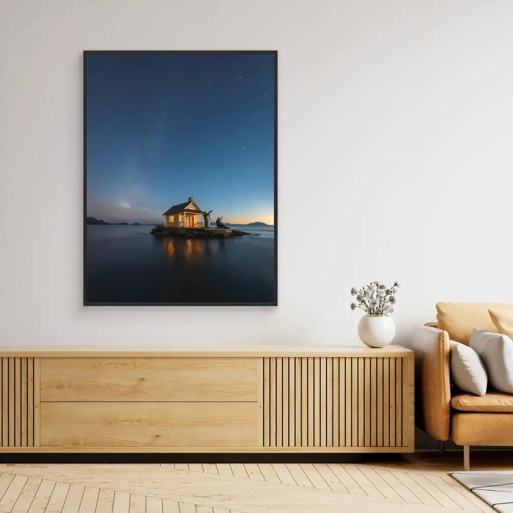 A framed photograph of a solitary cabin on stilts over calm water at dusk.