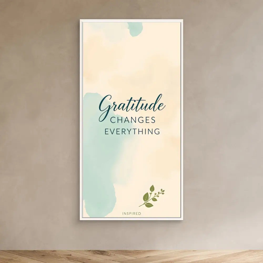 A minimalist wall art print featuring the quote ’Gratitude Changes Everything’ in mint green and cream colors with a small leaf accent.