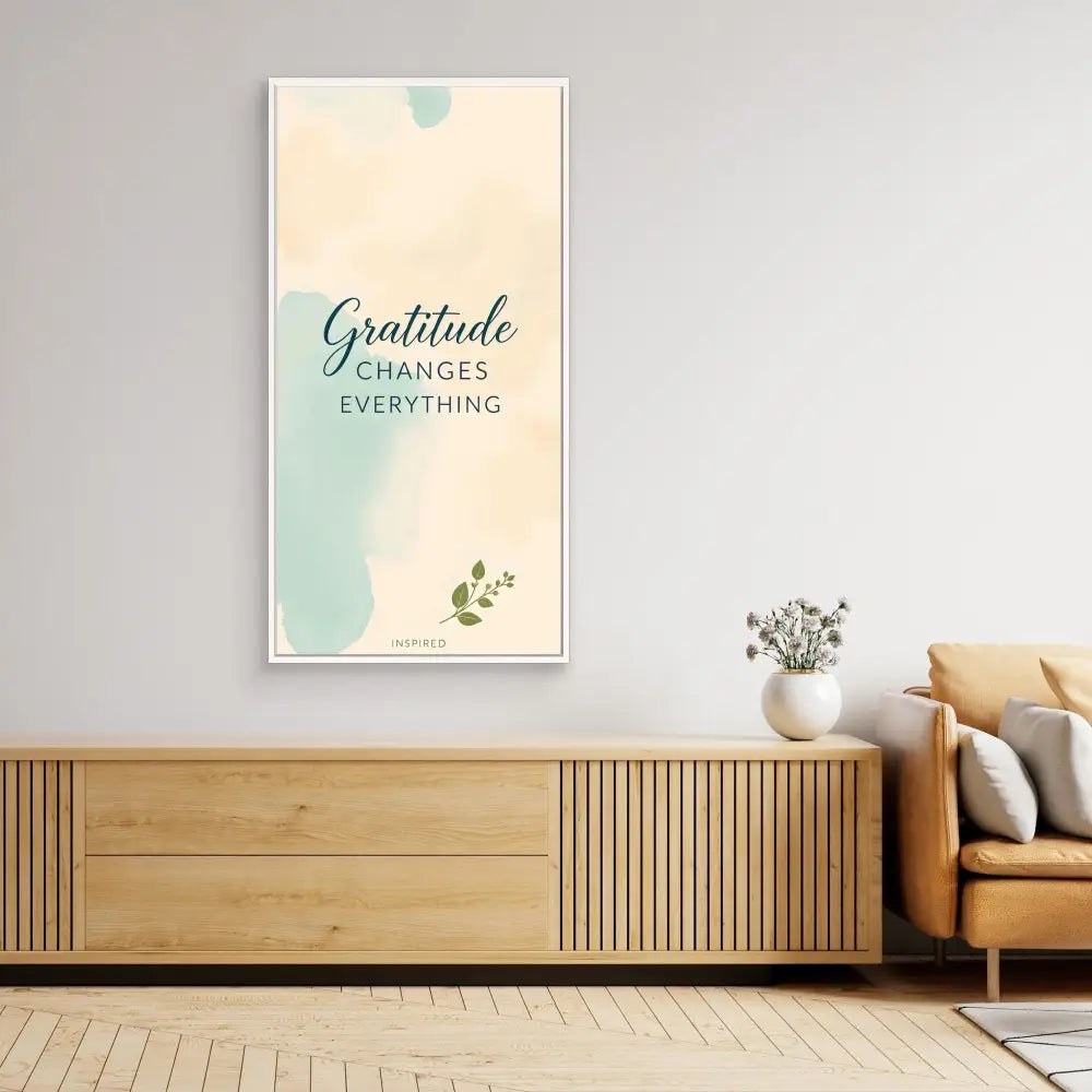 A minimalist wall art print featuring the text ’Gratitude changes everything’ in soft teal and beige tones.