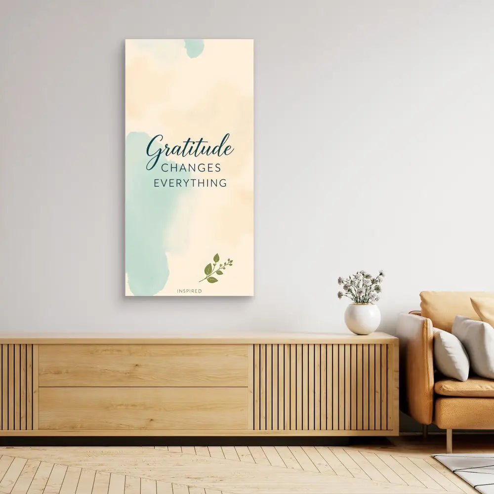 A minimalist wall art print featuring the text ’Gratitude changes everything’ in teal and cream colors.