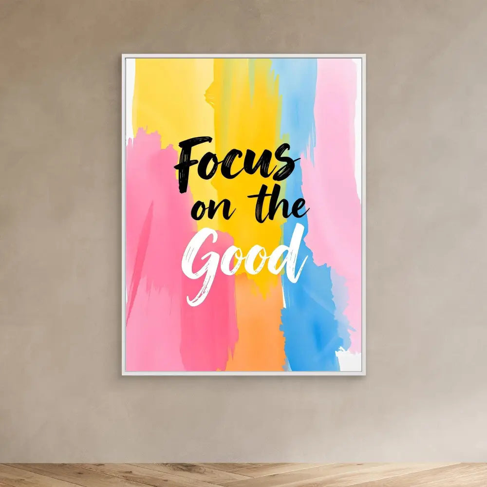 Motivational wall art featuring ’Focus on the Good’ text over watercolor-style pink, yellow and blue brushstrokes.