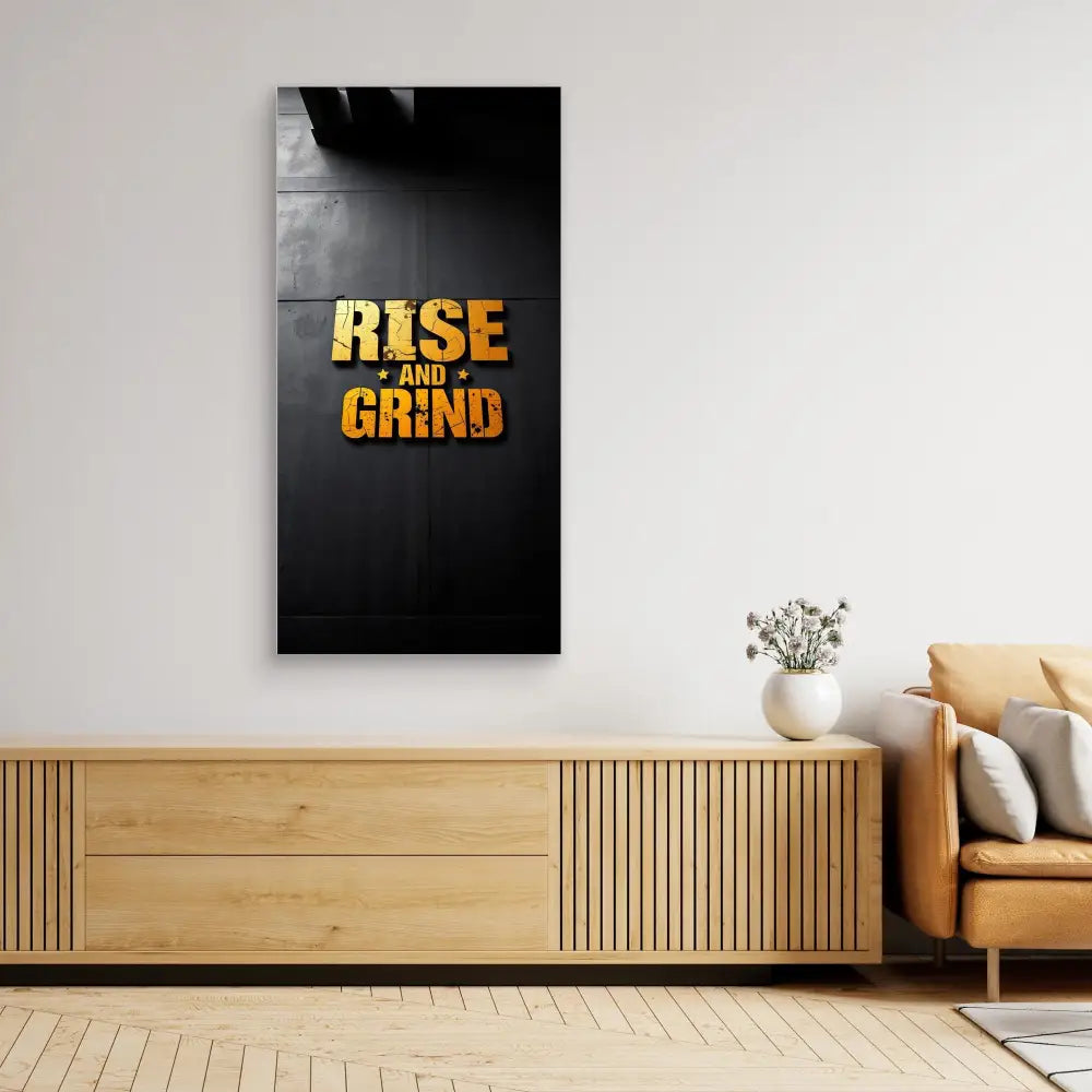 Motivational wall art featuring gold text ’RISE AND GRIND’ on a black background.