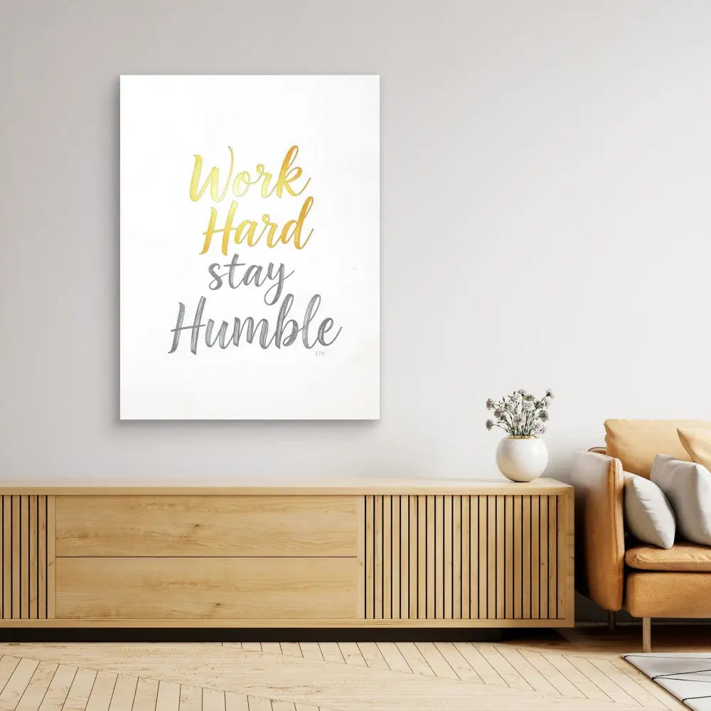 A motivational wall art print featuring the text ’Work Hard Stay Humble’ in yellow and gray lettering.