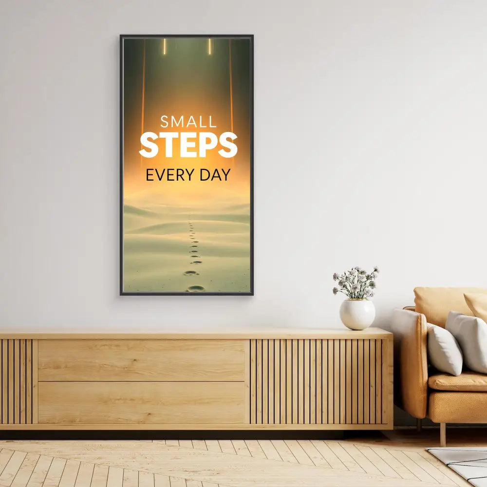 Motivational wall art displaying ’SMALL STEPS EVERY DAY’ text over footprints in sand.