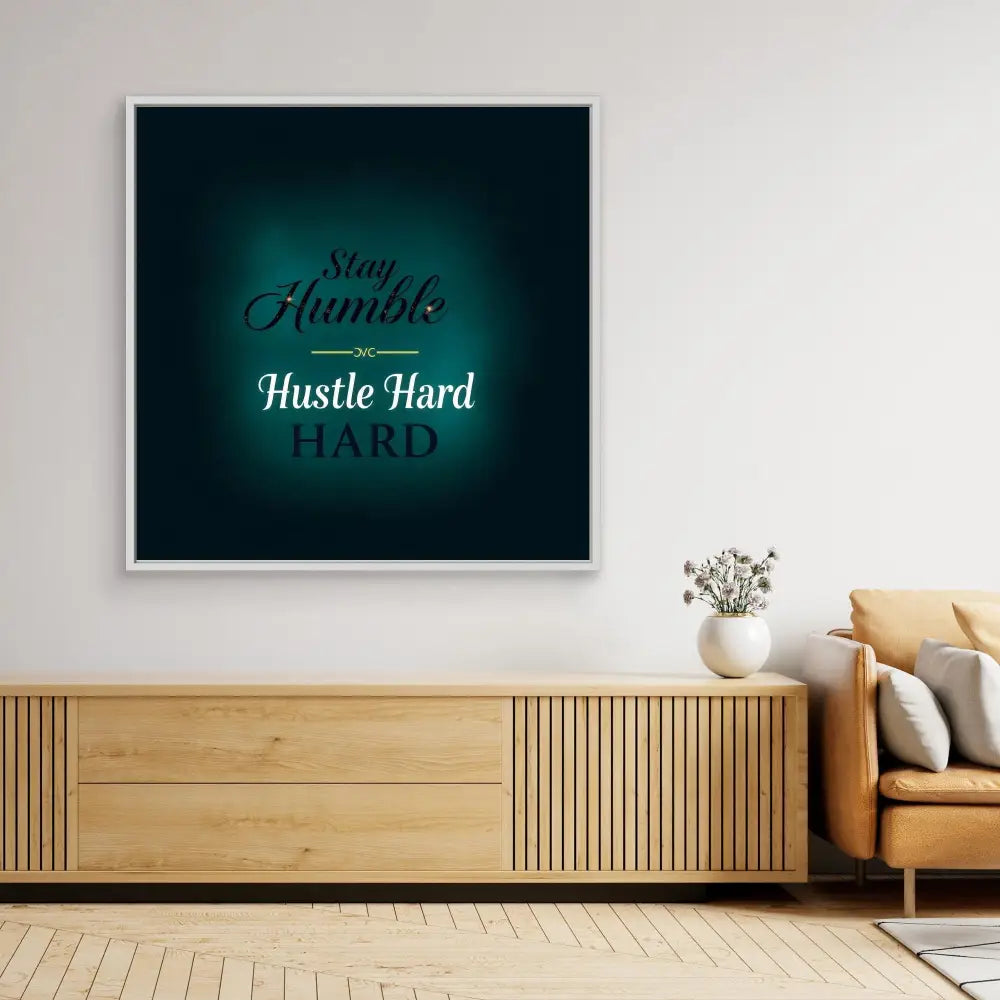 Motivational wall art with text ’Stay Humble Hustle Hard’ on a teal-colored background.