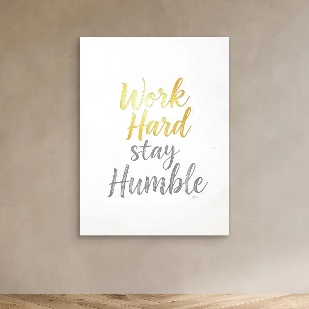 Motivational wall art featuring ’Work Hard Stay Humble’ text in gold and gray lettering.