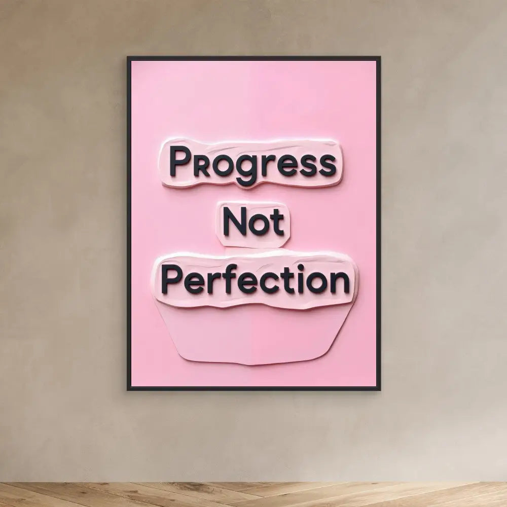 A pink motivational wall art displaying ’Progress Not Perfection’ in black text.